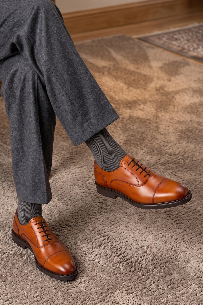 Model wearing Oswin Hyde Flint Tan, classic tan leather Oxford shoes with lace-up design, premium craftsmanship, breathable lining, and durable sole