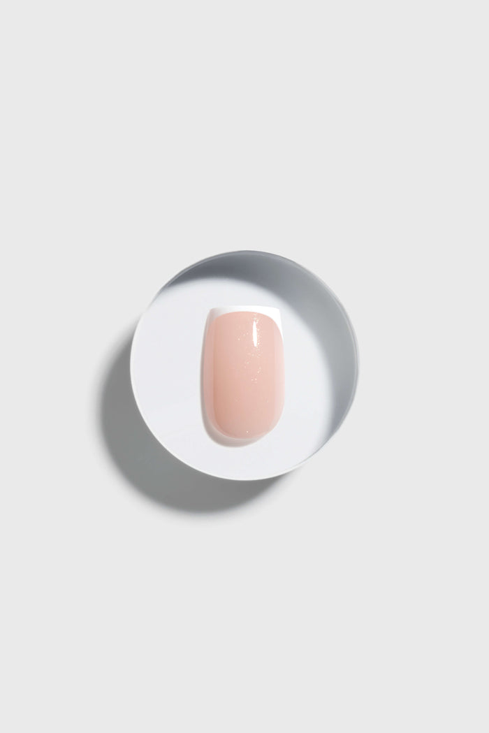 Coffin press-on nail on a white plate with a gray background