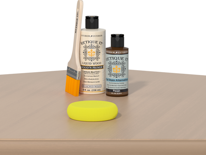 Retique It® Pecan Multipurpose Kit contents with Bleached Wood Liquid Wood primer, Pecan gel stain alternative, paintbrush, and yellow sponge displayed on a light wood surface.