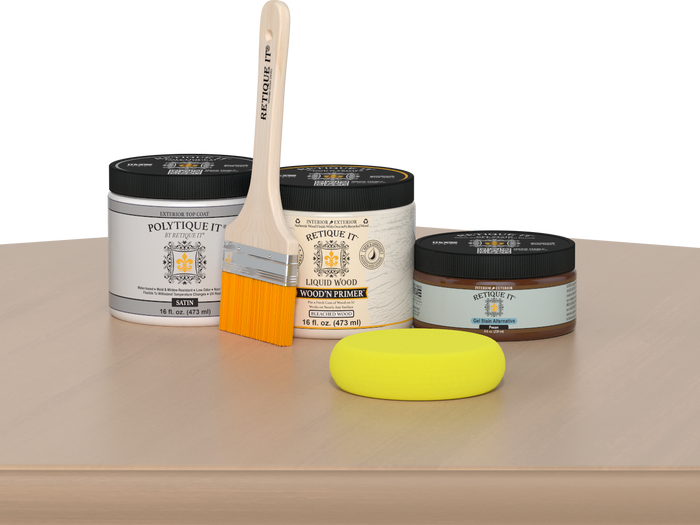 Retique It® White Oak Multipurpose Kit contents with Liquid Wood primer, Pecan gel stain alternative, satin exterior top coat, paintbrush, and yellow sponge displayed on a light wood surface.