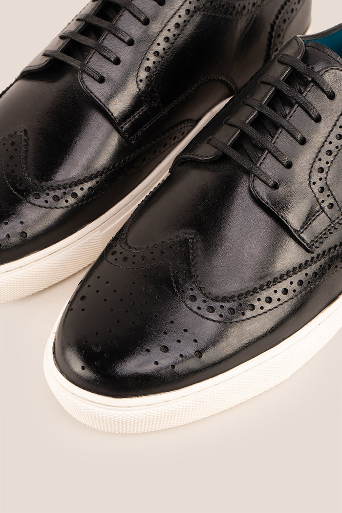 Stan Black wingtip brogue trainer shoes for men, crafted from premium leather with classic wingtip detailing and modern trainer sole.
