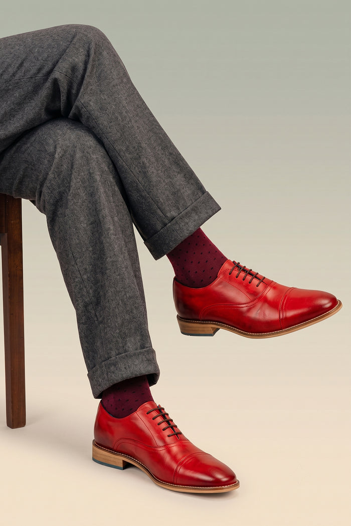 Model wearing William cherry red leather oxford shoes for men by Oswin Hyde – elegant toecap lace-up design with polished leather and timeless sophistication.