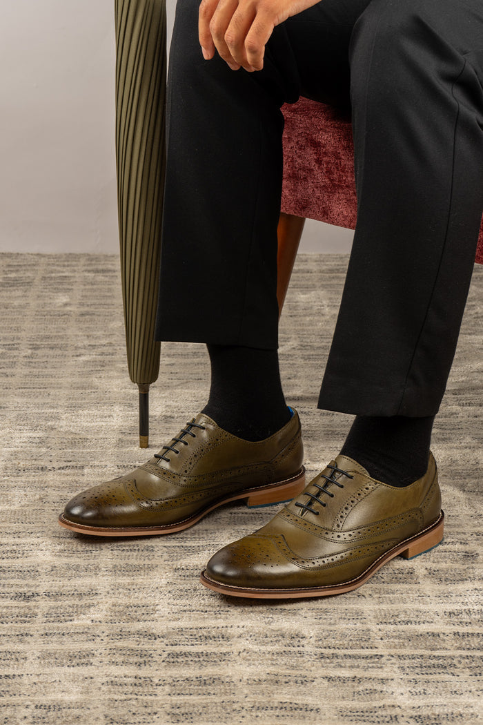 Winston men’s Oxford brogue shoes in green leather with wingtip detail, perforated accents, and a classic lace-up silhouette—crafted for formal distinction.
